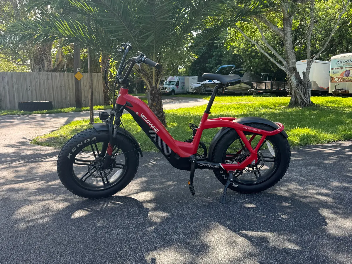 A scenic outdoor pathway lined with palm trees features an electric bike ready for exploration. The paved path and lush greenery evoke a sense of adventure and easy access to local highlights, perfect for a quick escape between work sessions or exploring the neighborhood.